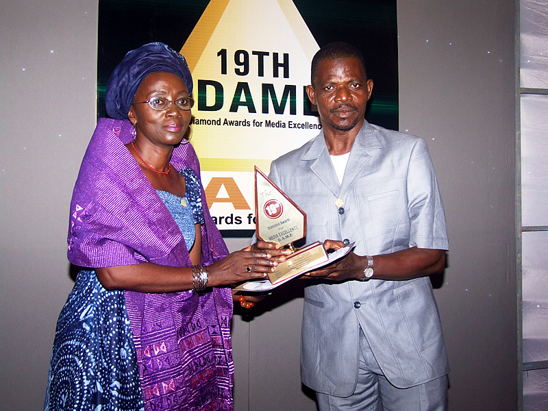 <span  class="uc_style_uc_tiles_grid_image_elementor_uc_items_attribute_title" style="color:#ffffff;">bayoor ewuoso receivng his action photography prize from bunmi davies</span>