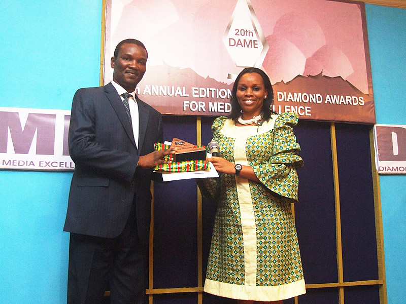 <span  class="uc_style_uc_tiles_grid_image_elementor_uc_items_attribute_title" style="color:#ffffff;">UNCEF's Blessing Ejiofor presenting the Press Advert Services prize to Rosaabel's MD</span>